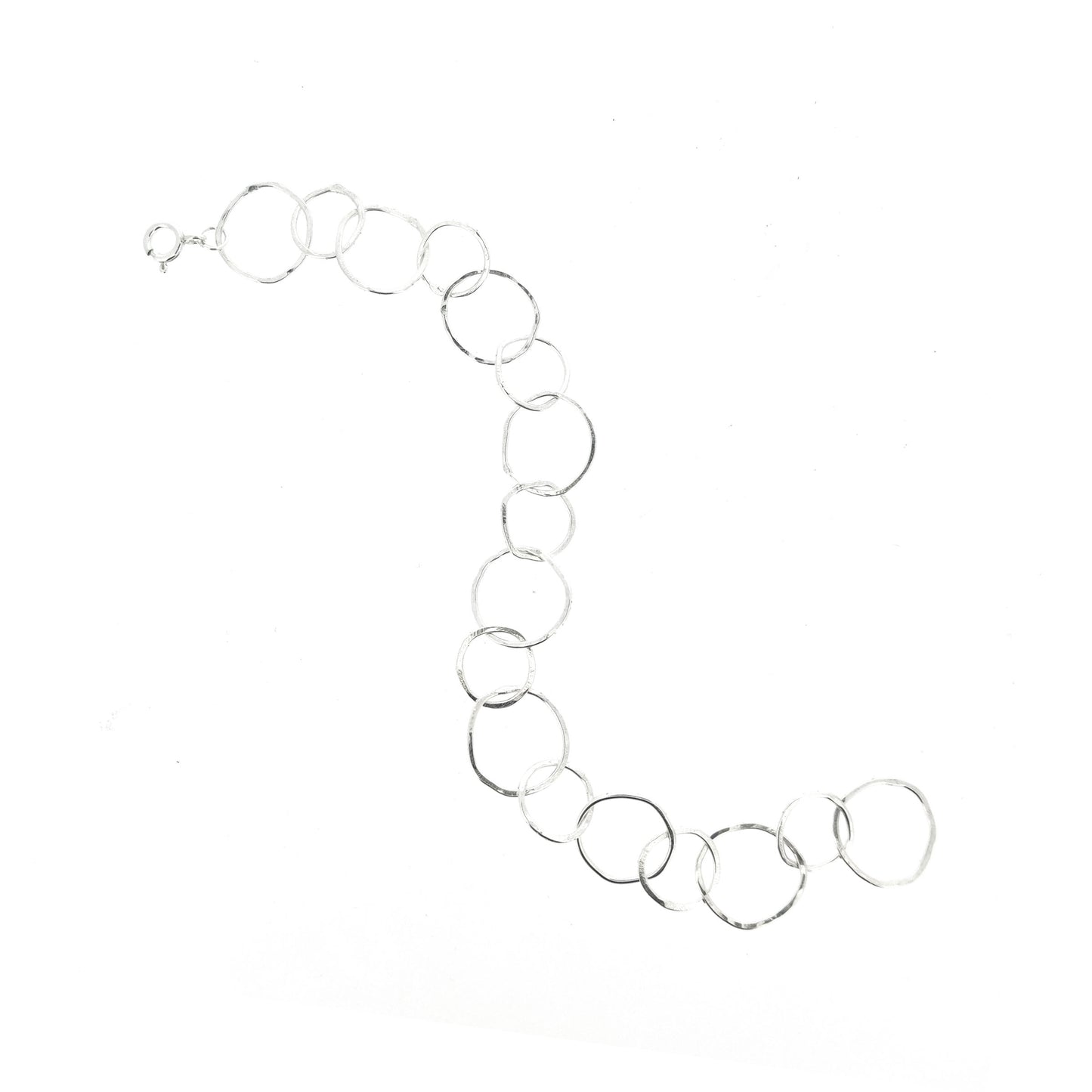 A silver chain link bracelet with delicate links of various sizes in an organic circle shape.