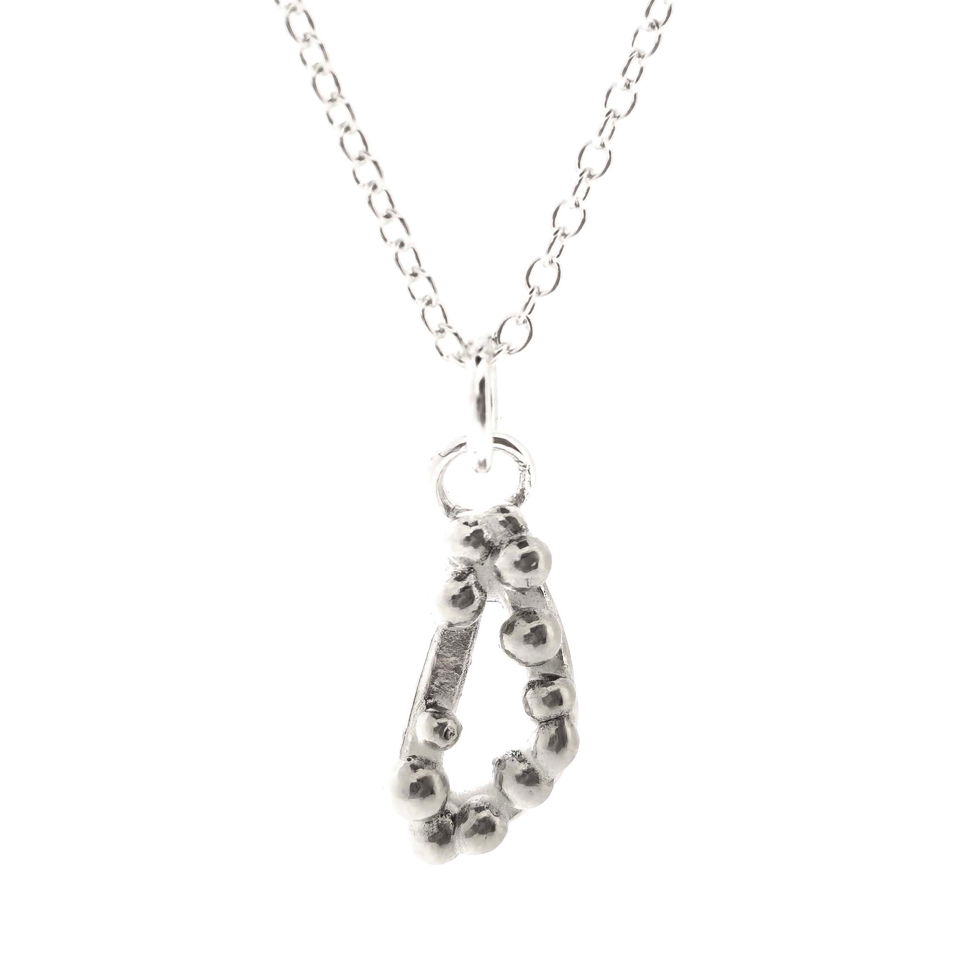 Silver asymmetric open triangle pendant with silver balls on a silver chain. Shown on a white background.