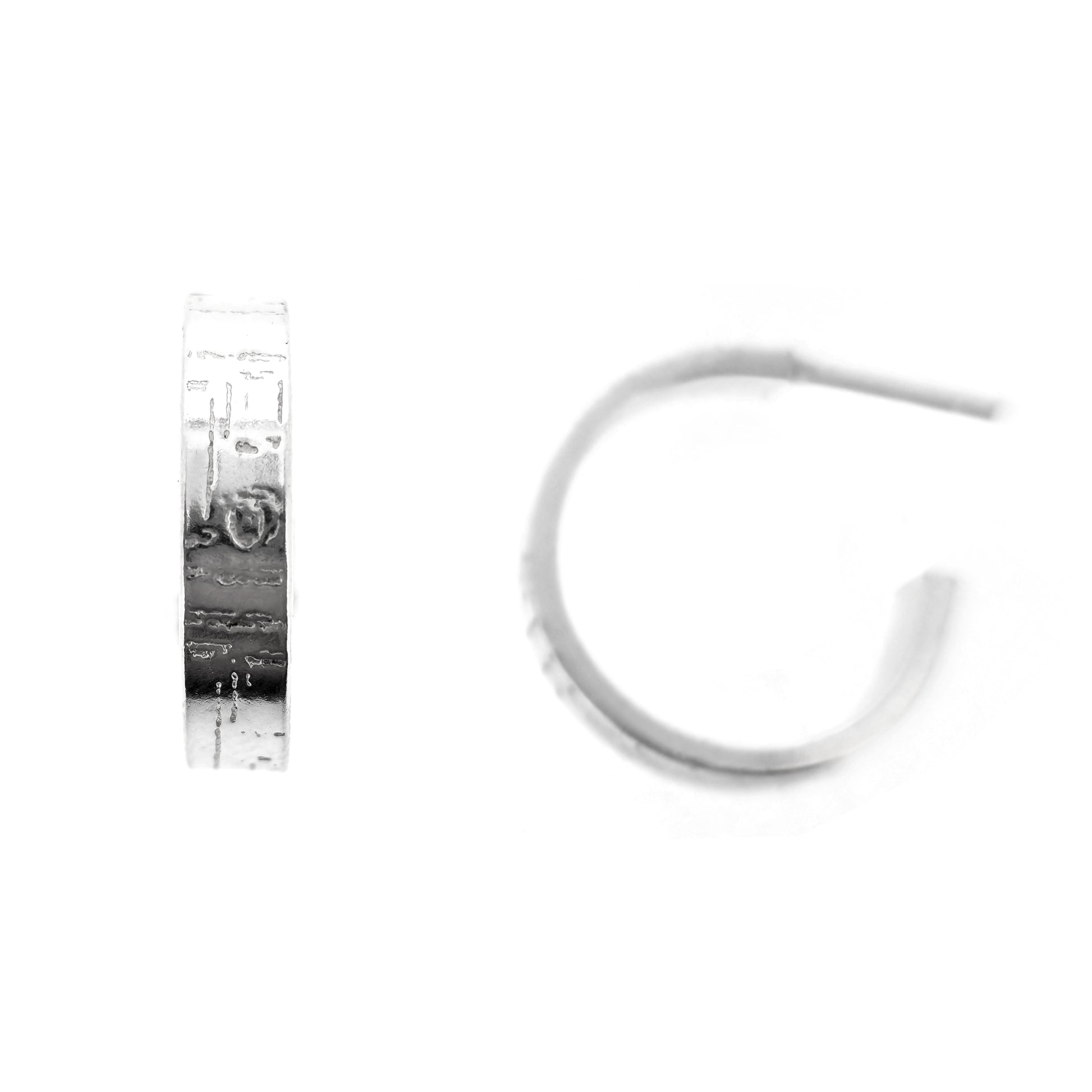A pair of silver flat hoop earrings with a square and line pattern on.