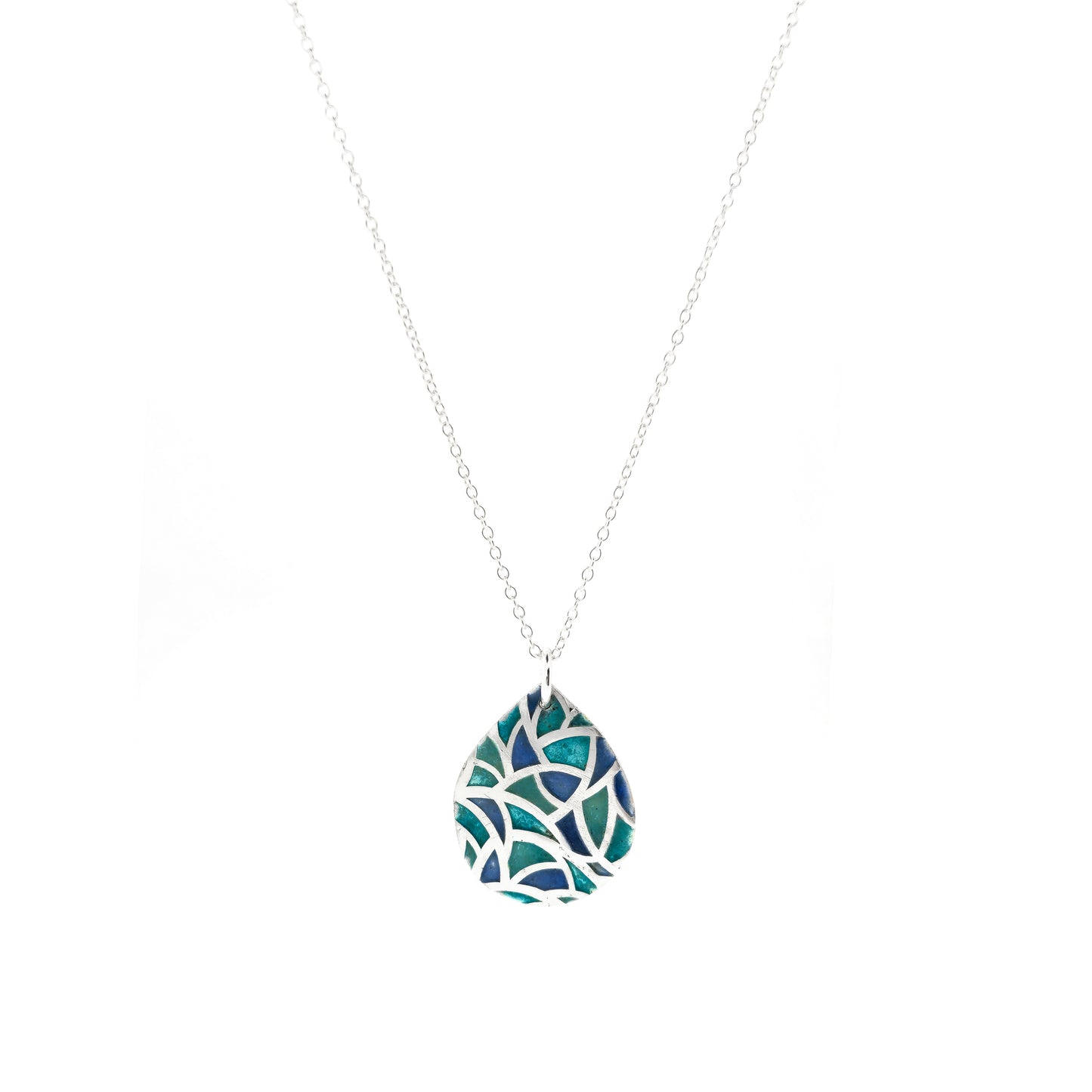 A teardrop shaped silver pendant with geometric cells of blue, green and turquoise enamel. On a silver chain.