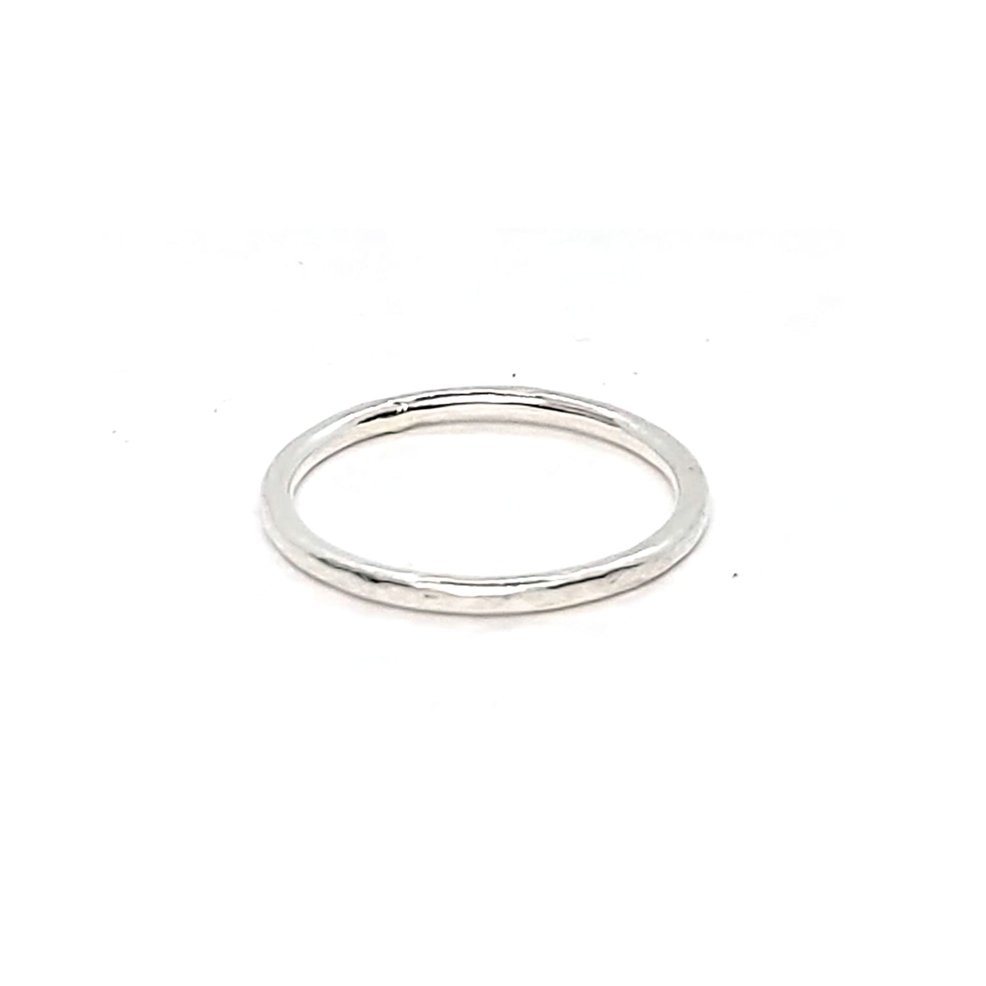 A thin silver stacking ring with a hammered finish.
