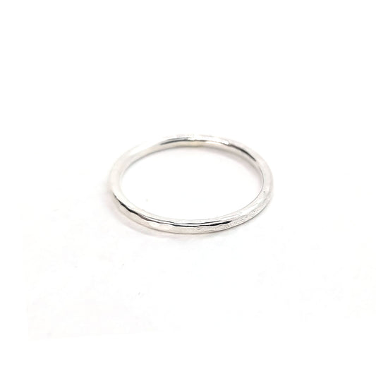 A thin silver stacking ring with a hammered finish.