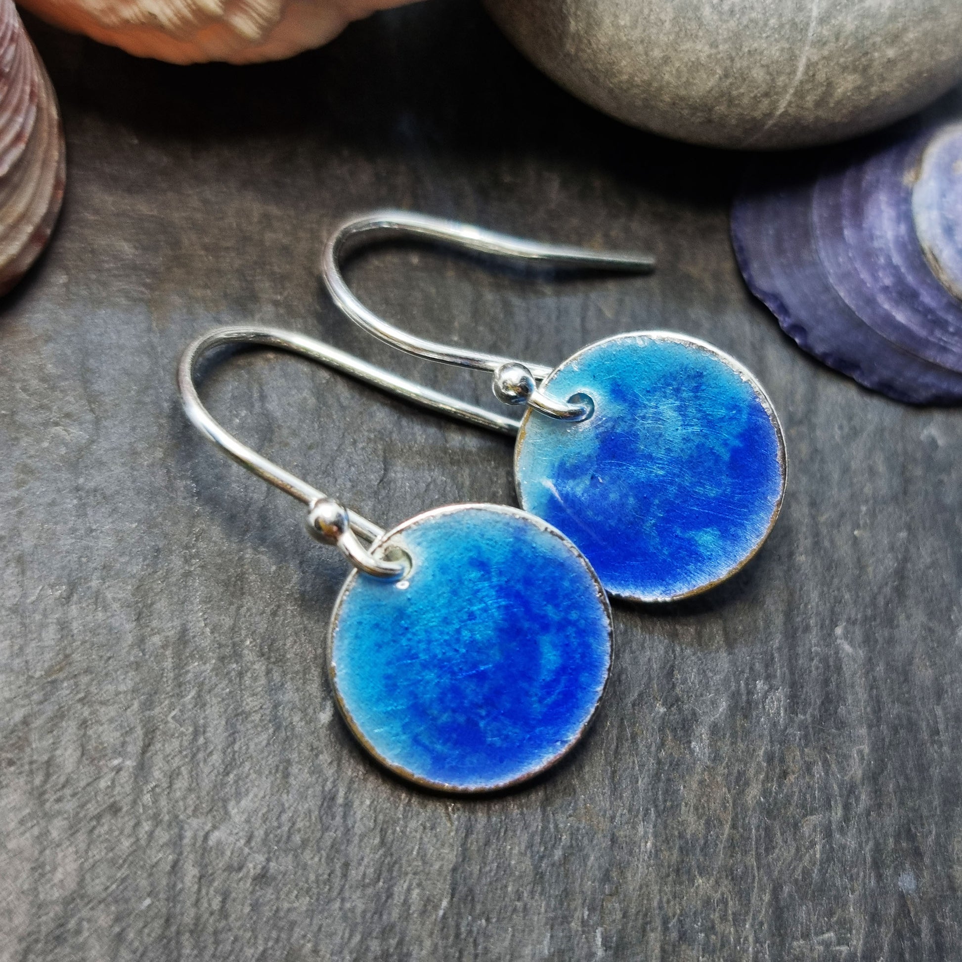 Silver round drop earrings with a mix of dark and light blue enamel.