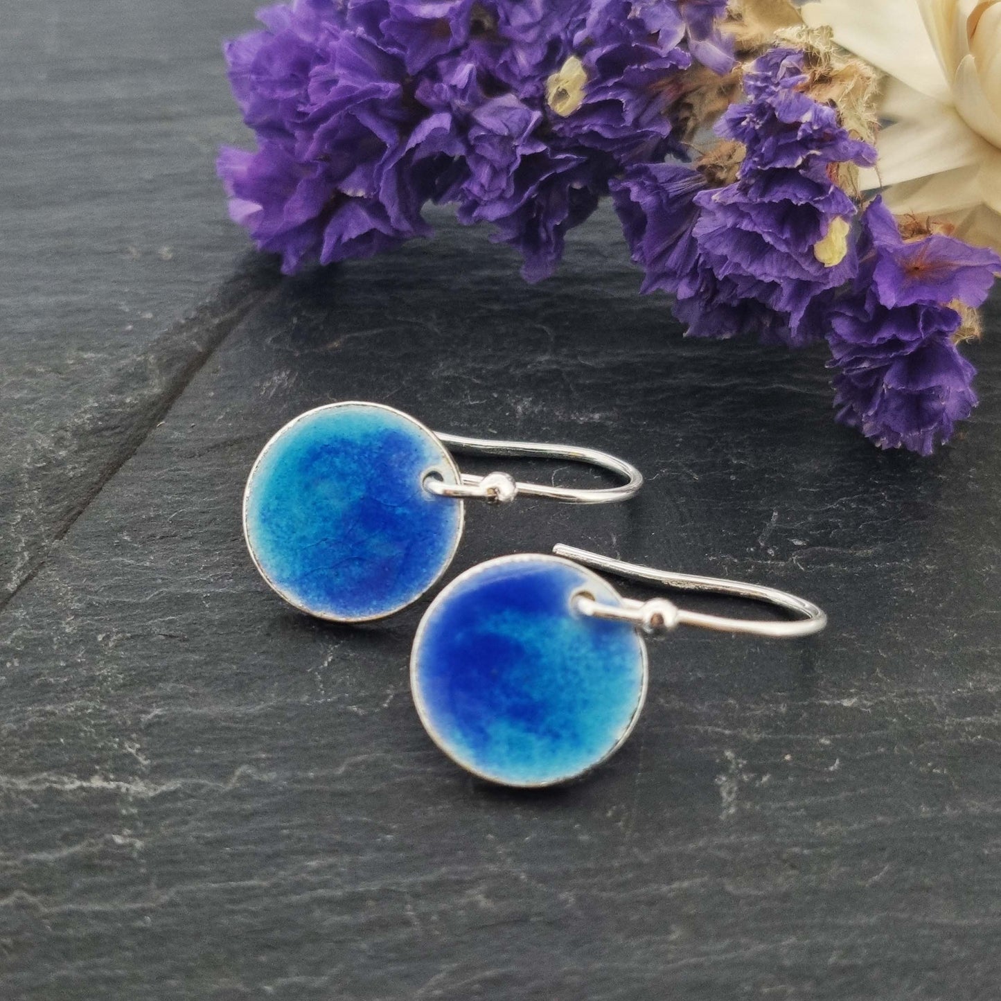 Silver round drop earrings with a mix of dark and light blue enamel.