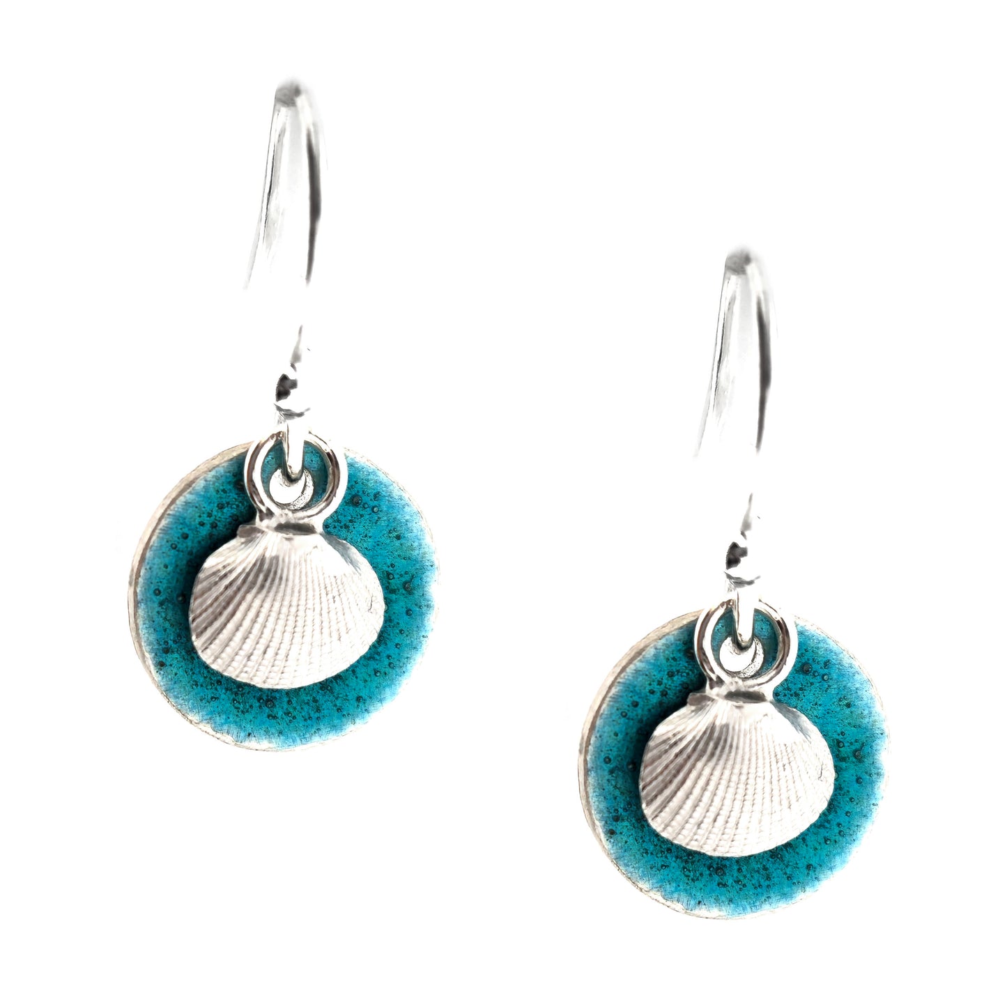 A pair of handmade silver earrings with a turquoise enamel disc and a silver cockle shell on front. On a white background. Mijoux Jewellery.