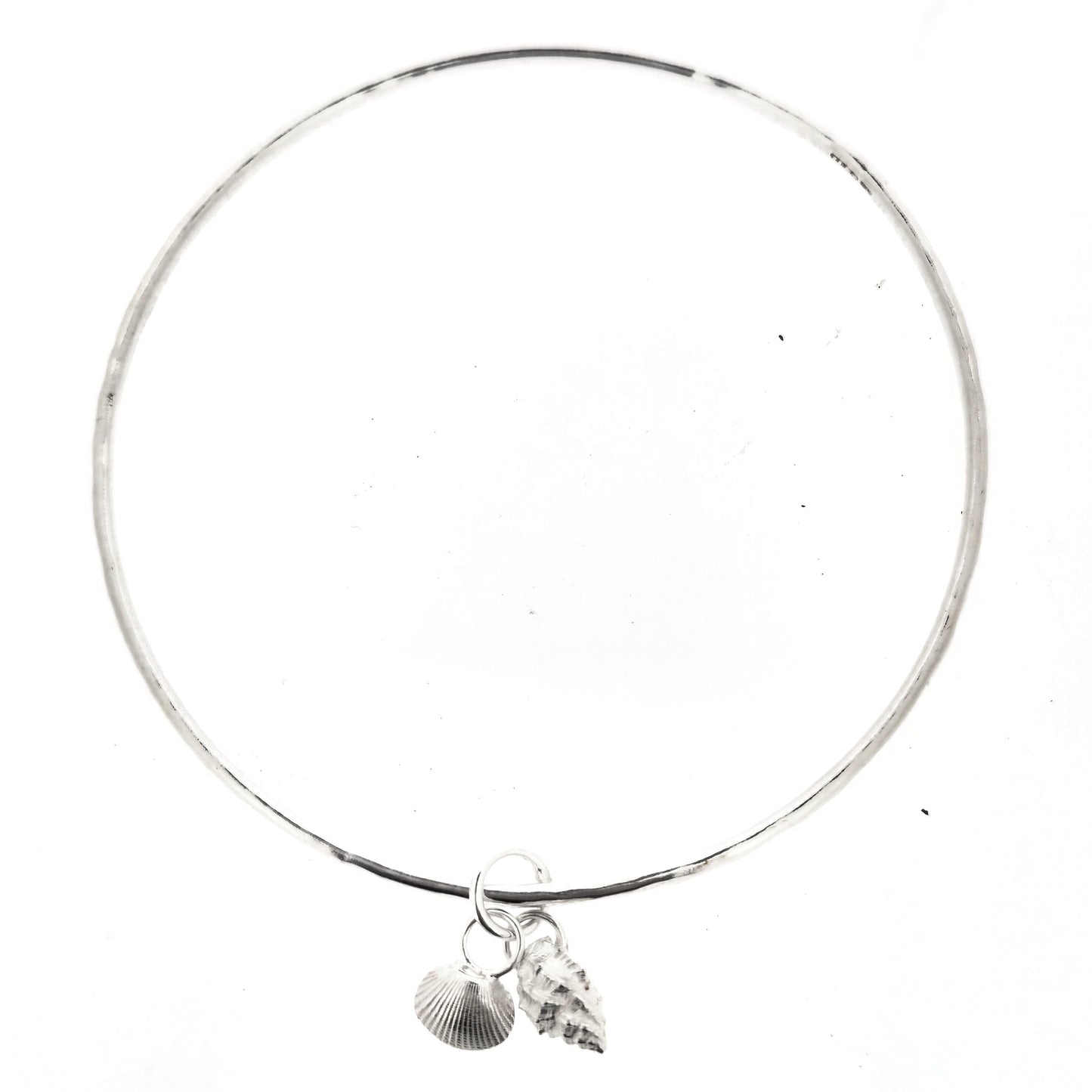 A round silver bangle with 2 seashell charms. 1 cockle shell and 1 periwonkle shell. On a white background. Handmade, Mijoux Jewellery.