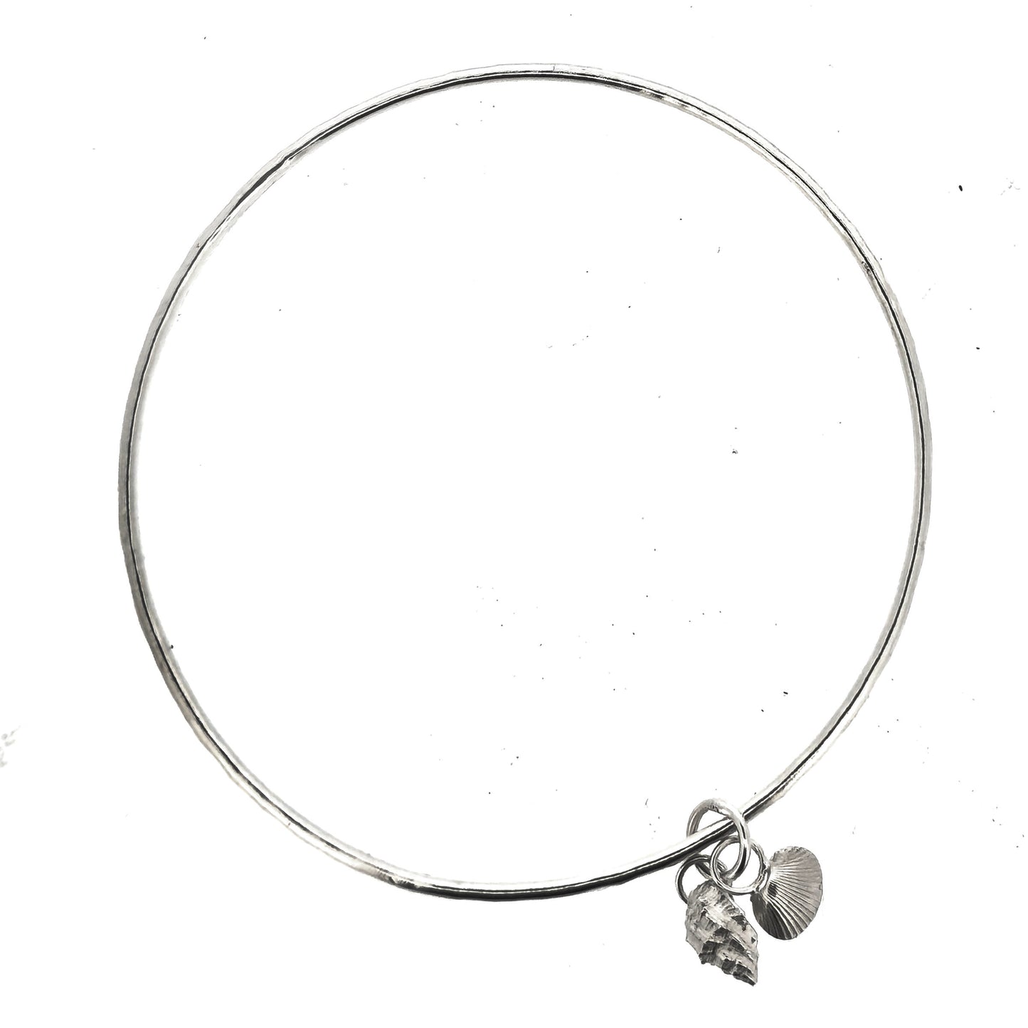 A round silver bangle with 2 seashell charms. 1 cockle shell and 1 periwonkle shell. On a white background. Handmade, Mijoux Jewellery.