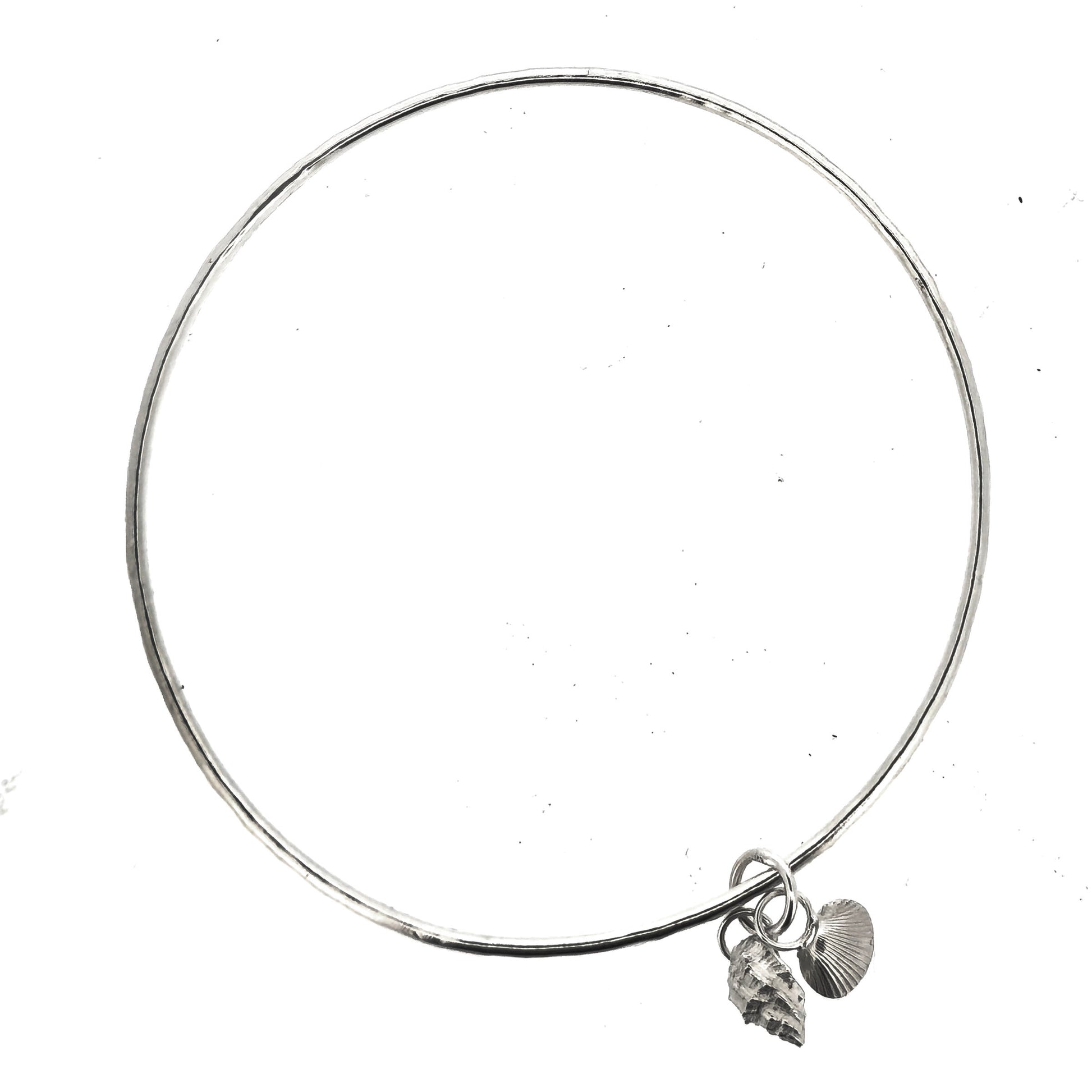 A round silver bangle with 2 seashell charms. 1 cockle shell and 1 periwonkle shell. On a white background. Handmade, Mijoux Jewellery.