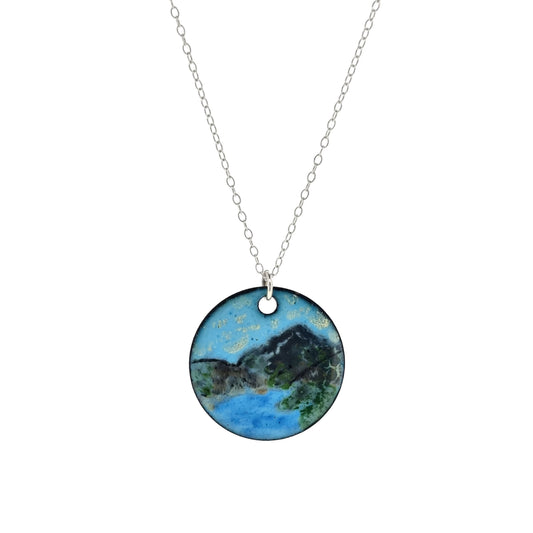 Round enamel pendant on silver chain. The pendant shows a landscape scene with a mountain and lake.