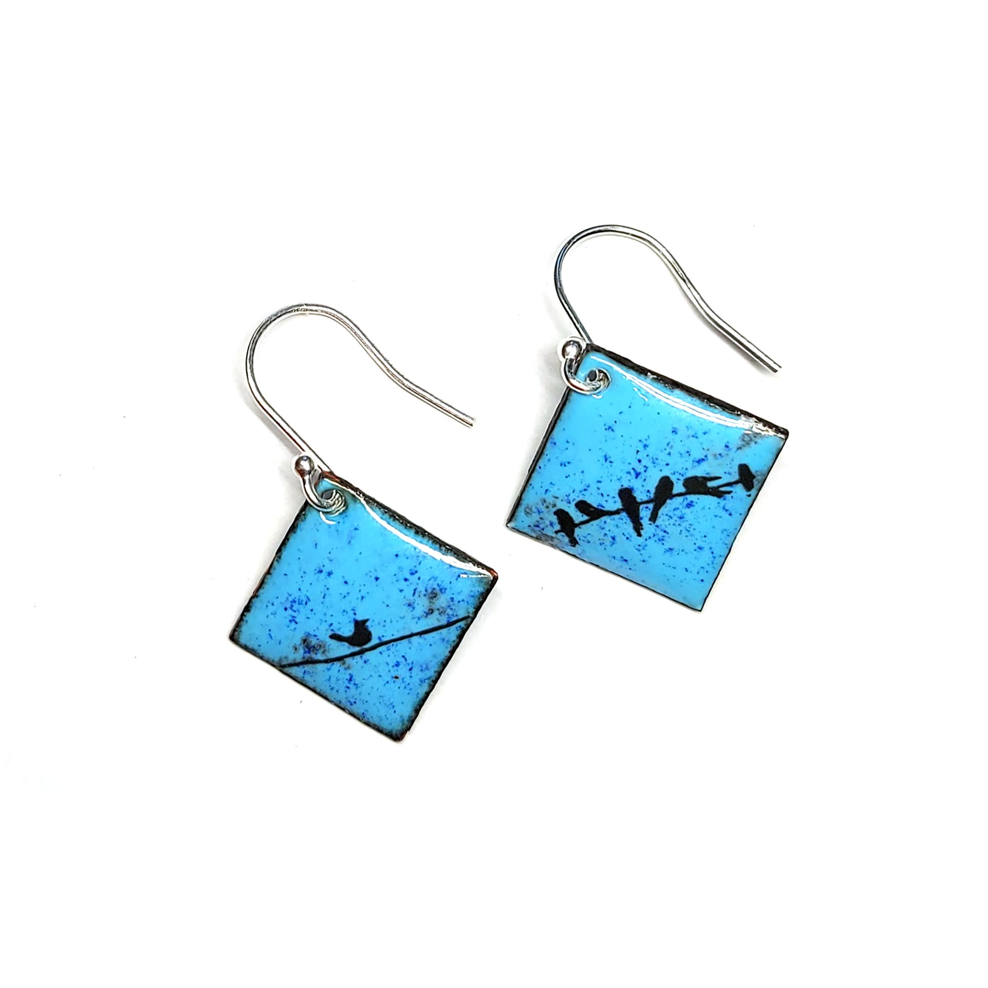 Square drop earrings featuring silhouettes of birds sitting on a wire against a blue enamel background.