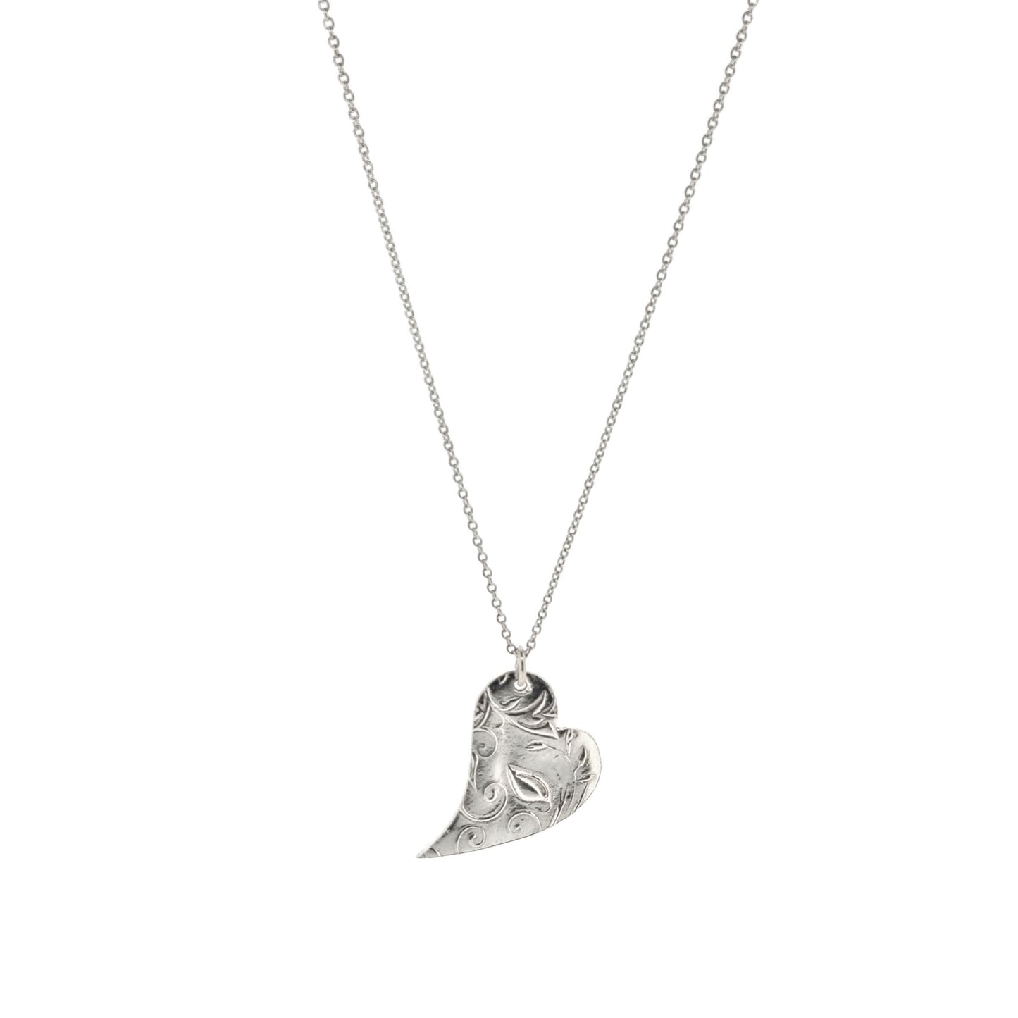 A silver asymmetrical heart pendant with a leaf and vine pattern suspended on a silver chain - large