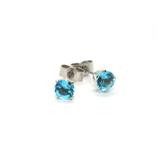 Silver 4 claw stud earrings with bright blue topaz gemstones.