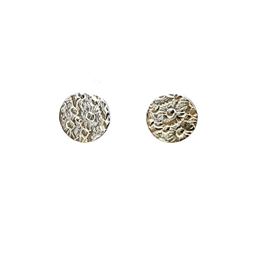 Round silver stud earrings with a pattern of flowers.