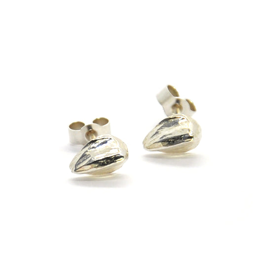 Silver teardrop shaped stud earrings with lined texture.