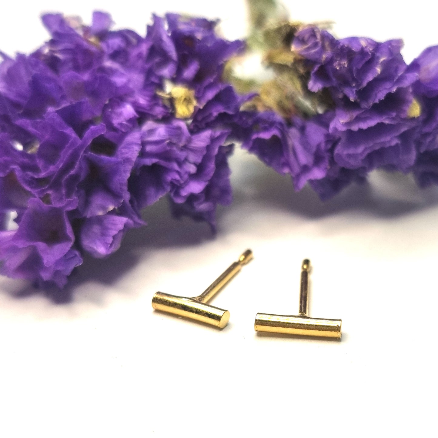 Yellow gold vermeil rounded bar stud earrings. Pictured with flowers.