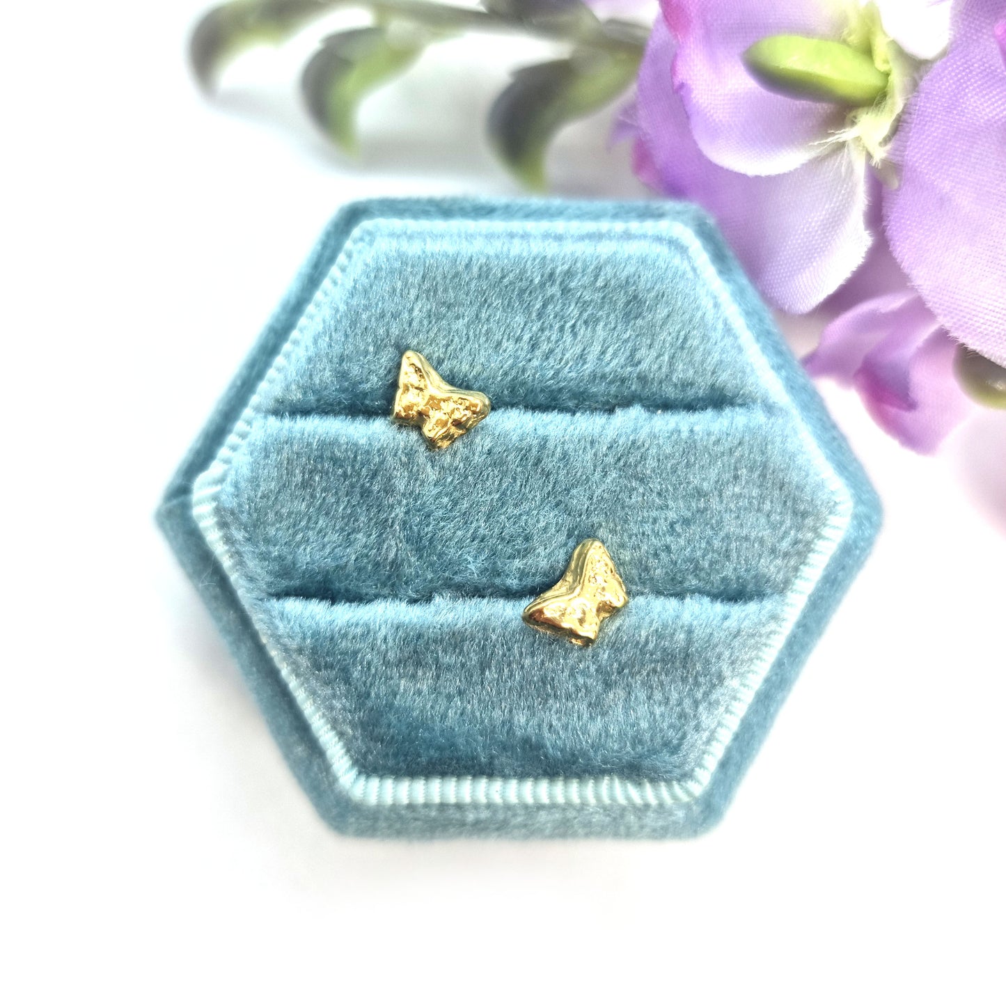 Yellow gold vermeil tiny textured butterfly stud earrings. Pictured in a jewellery box with flowers.