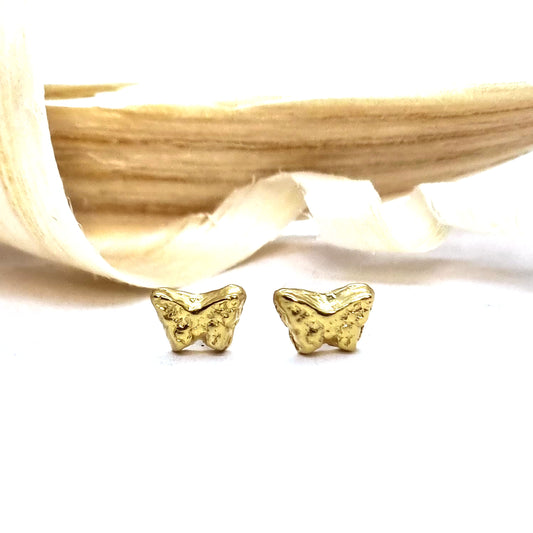 Yellow gold vermeil tiny textured butterfly stud earrings. Pictured with wood shavings.