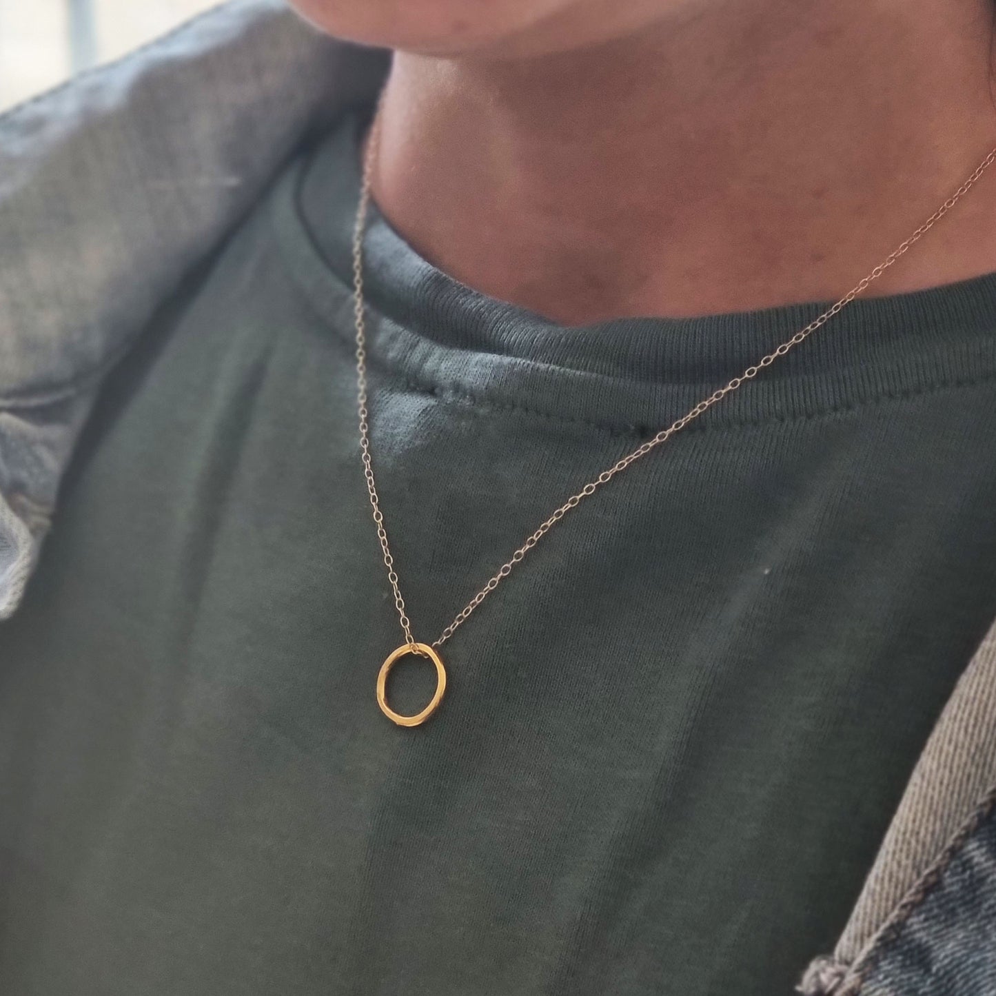 Yellow gold vermeil open circle pendant with hammered texture on a yellow gold vermeil chain. Small, pictured on person.