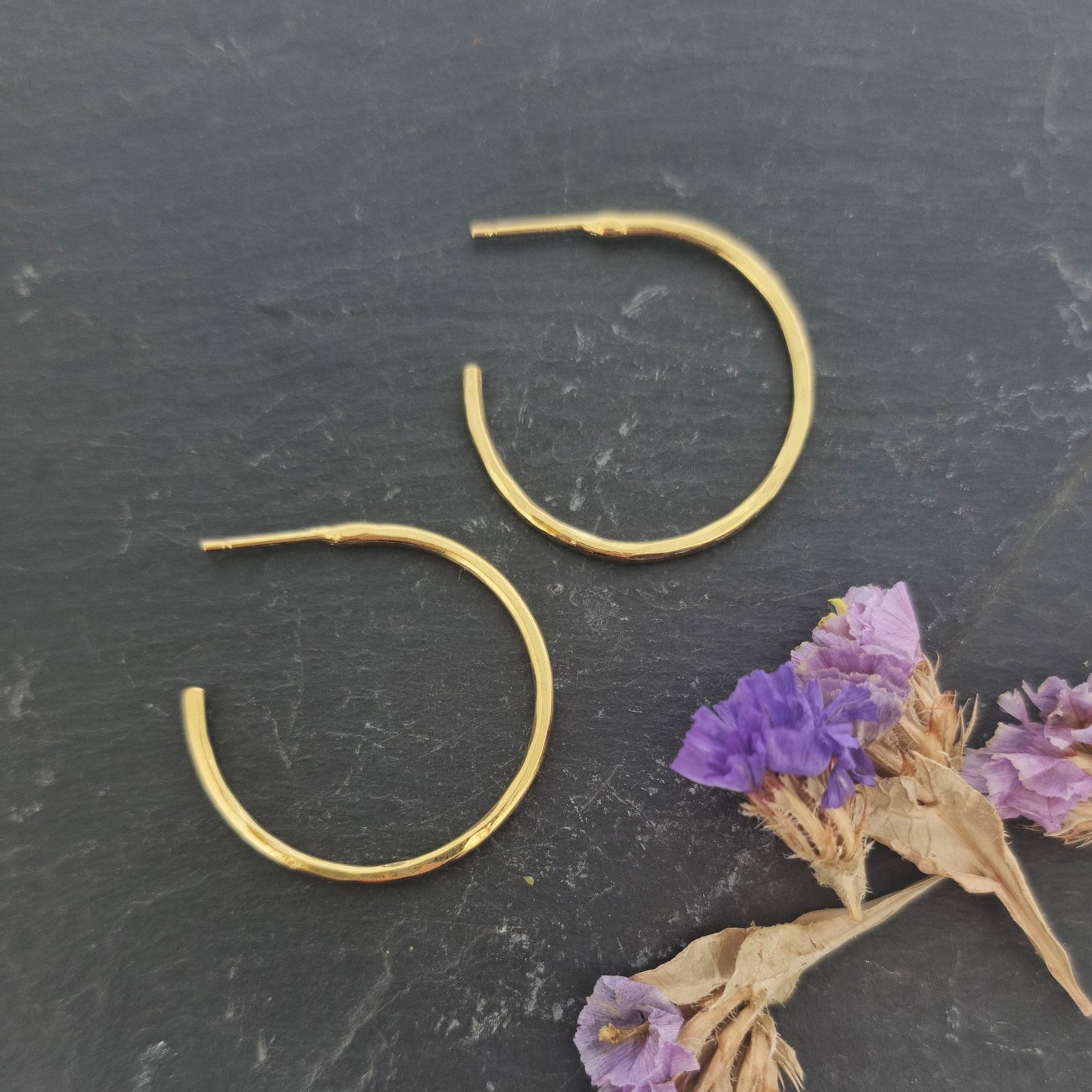 Yellow gold vermeil thin hammered hoop earrings, large. Pictured with flowers.