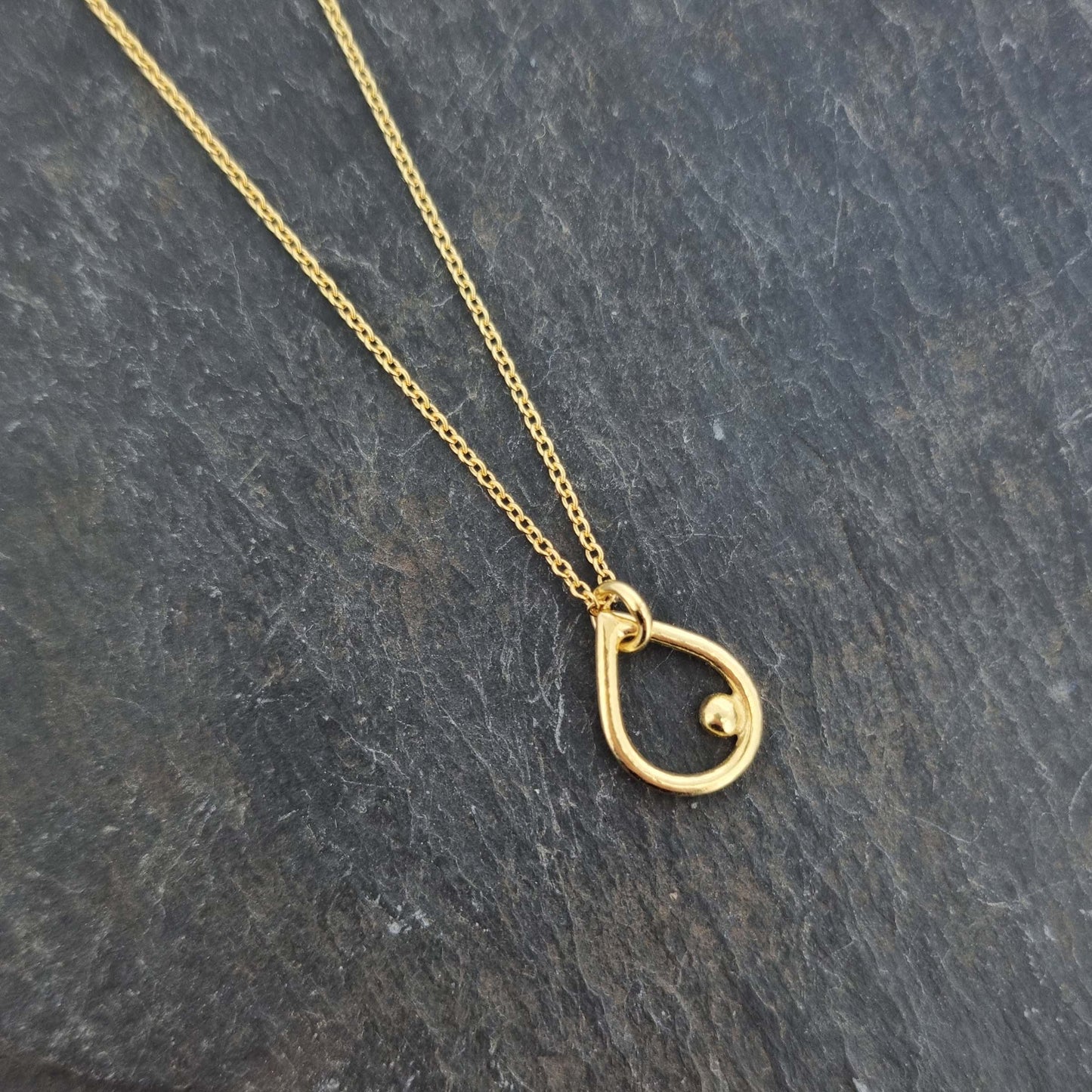Yellow gold vermeil open teardrop shaped pendant with an off-centre ball on a yellow gold vermeil chain.