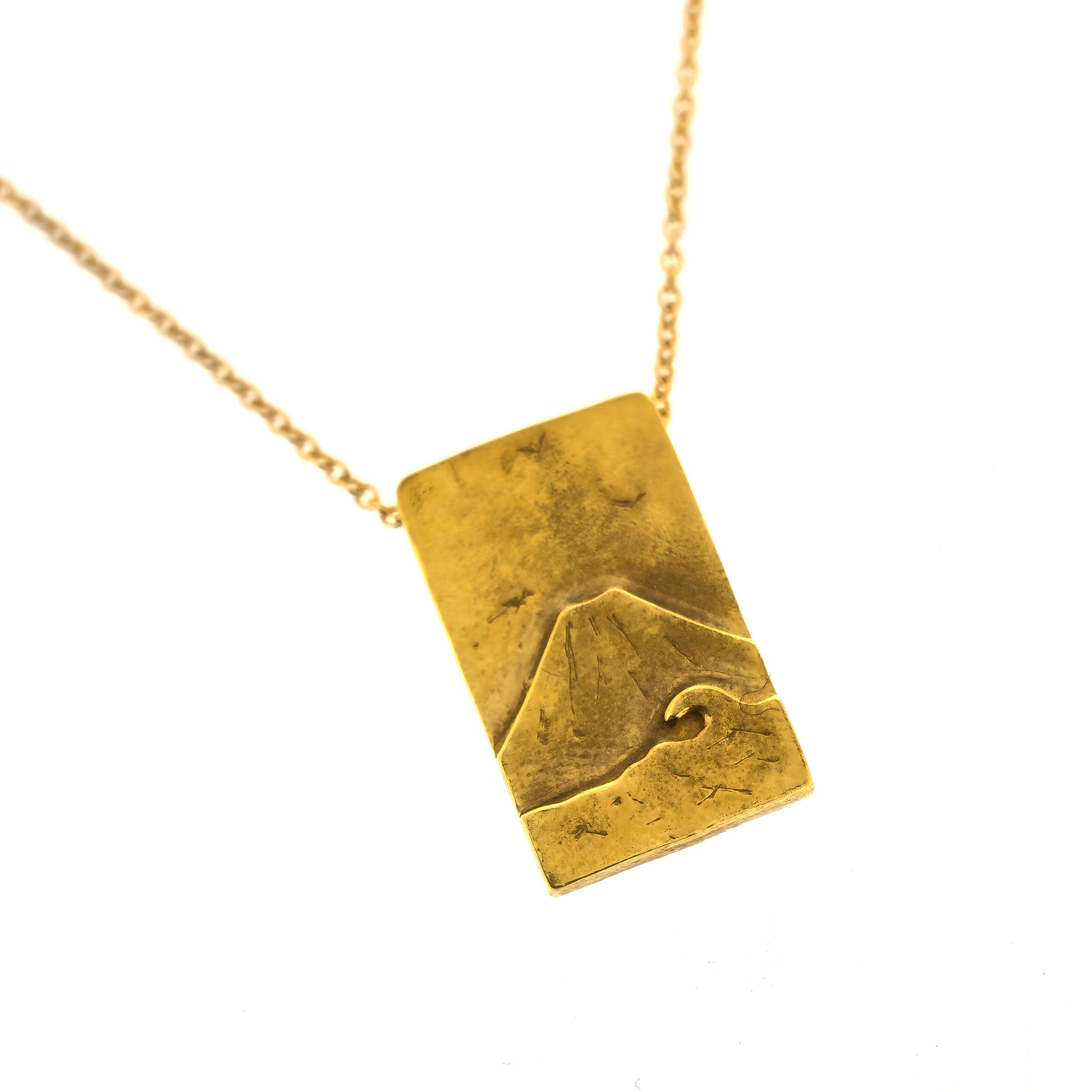 A rectangular yellow gold vermeil pendant featuring a mountain and sea scene. The pendant has an invisible bail and is on a yellow gold vermeil chain.