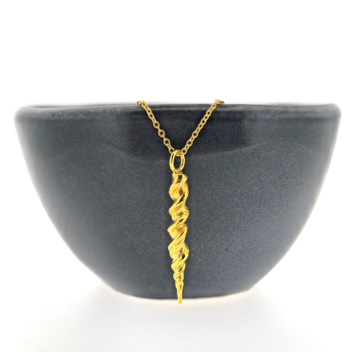 Yellow gold vermeil twist pendant on a yellow gold vermeil chain. Shown on a black bowl.