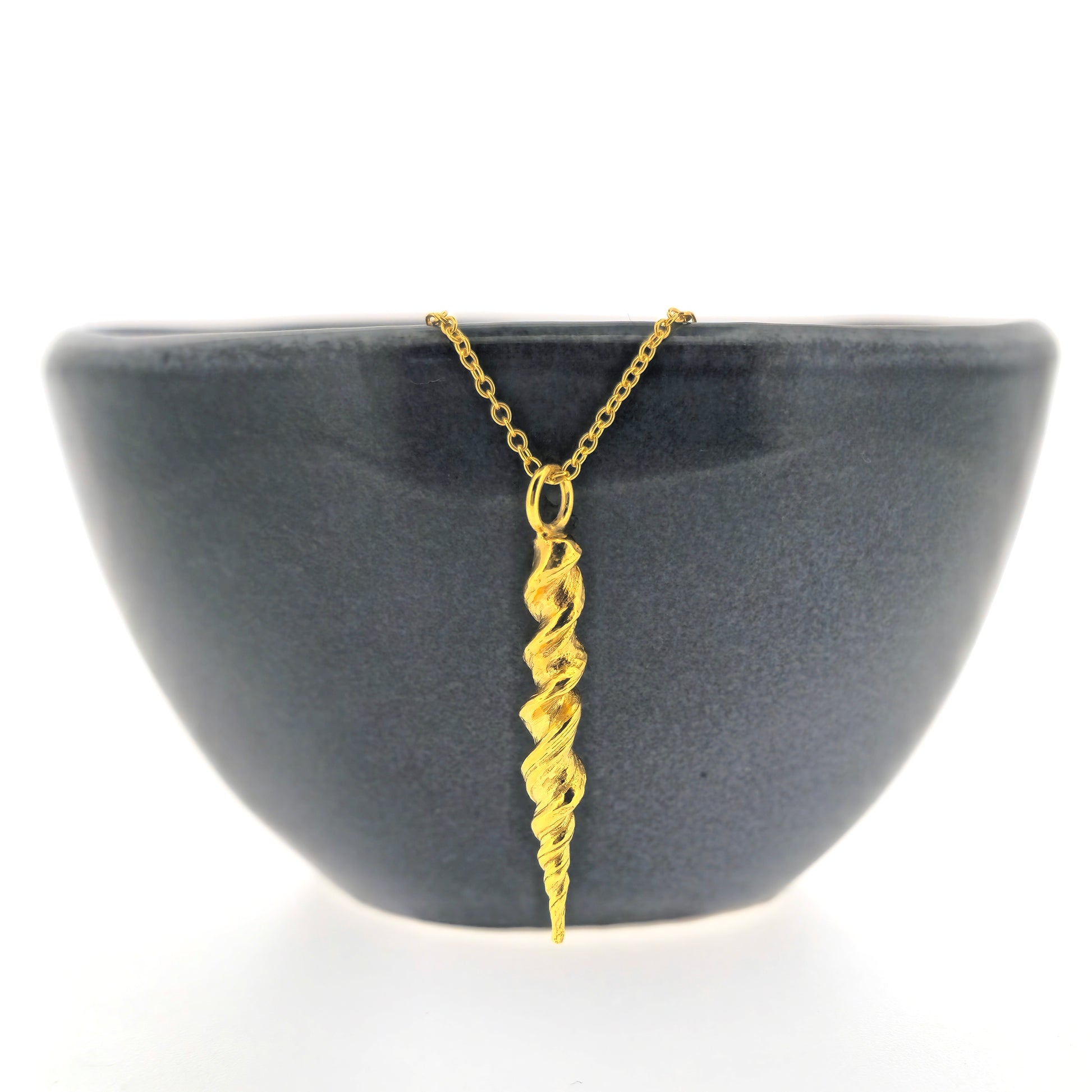 Yellow gold vermeil twist pendant on a yellow gold vermeil chain. Shown on a black bowl.