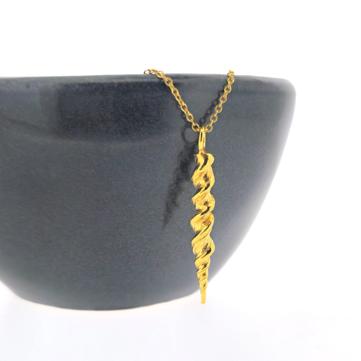 Yellow gold vermeil twist pendant on a yellow gold vermeil chain. Shown on black bowl.